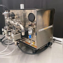 Load image into Gallery viewer, Rear side of the FG-200 bottle filling machine showing long 120VAC power cord and back of bottle positioning rail on a stainless steel table