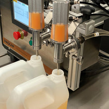 Load image into Gallery viewer, N100-S stainless sanitary nozzles filling 128oz gallon bottles from the benchtop FG-200 filling machine